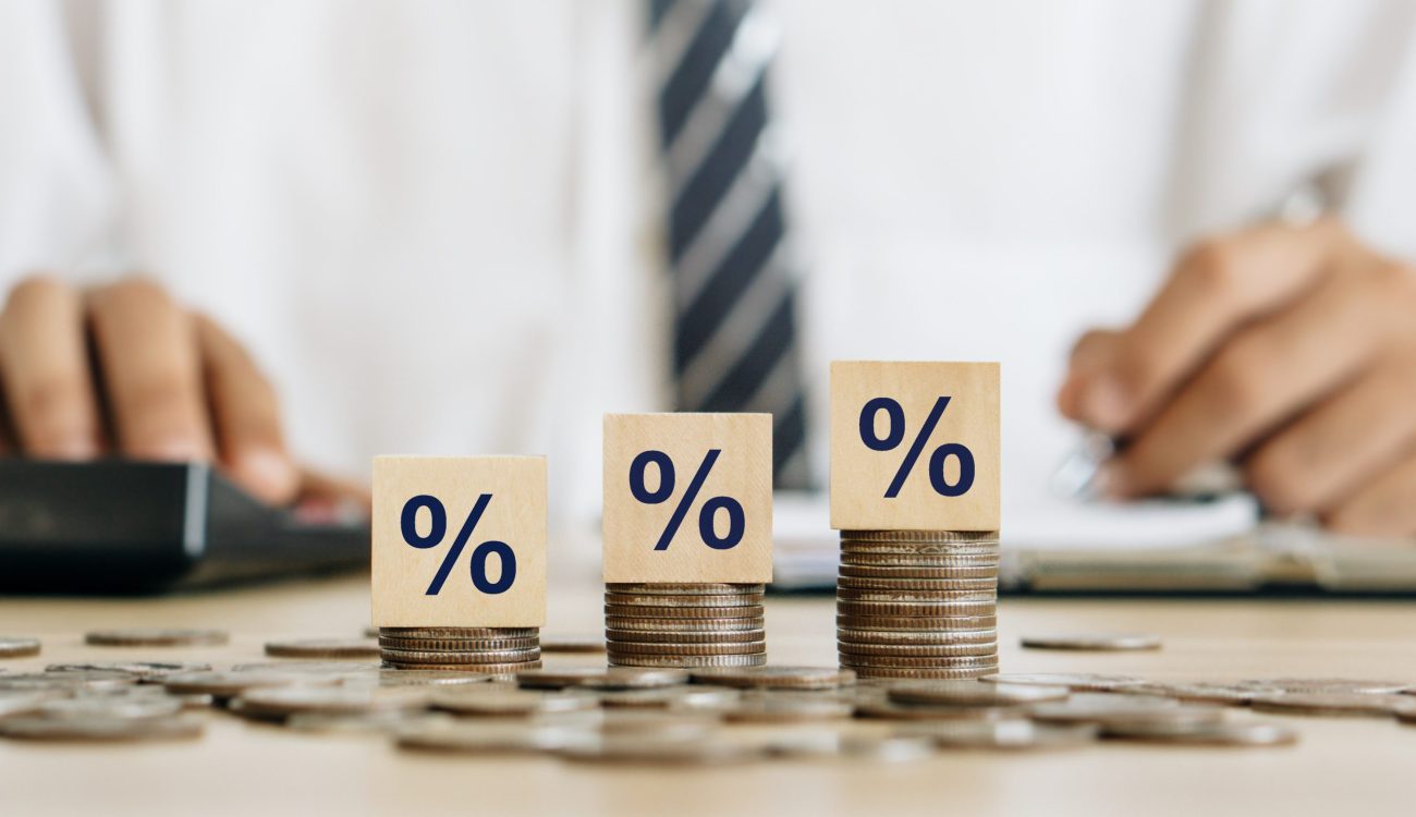 Interest rate concept.Wooden block with percentage symbol on stack of coins.Accountant analyzes annual interest.Tax,financial growth, increase, hyperinflation, inflation, recession concept.